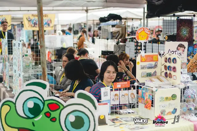 An artist at her stall selling stickers and prints at the art market