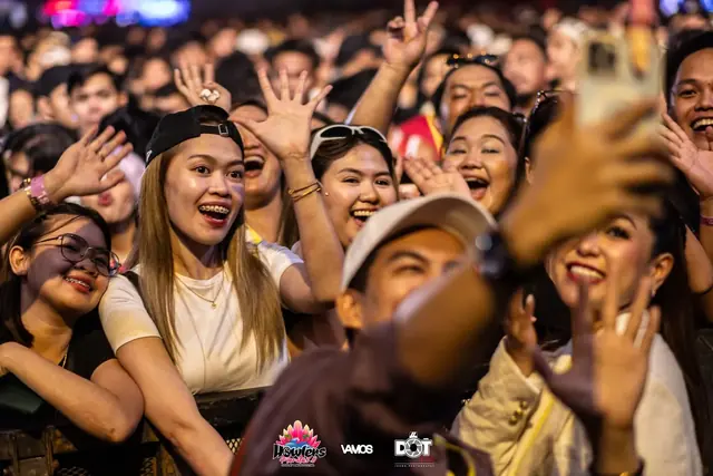 Fans smiling and cheering at the barrier