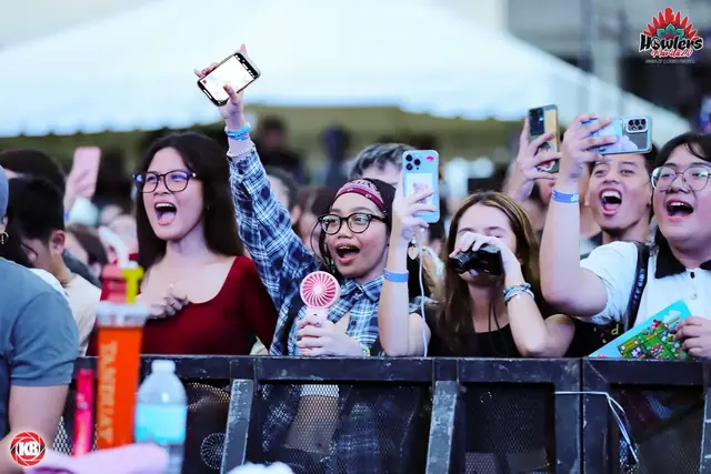 Fans cheering and filming at the barrier