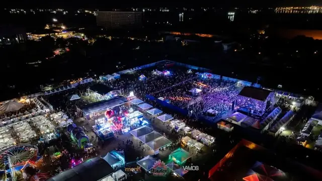Aerial view of the festival grounds at night, with the crowd in front of the main stage